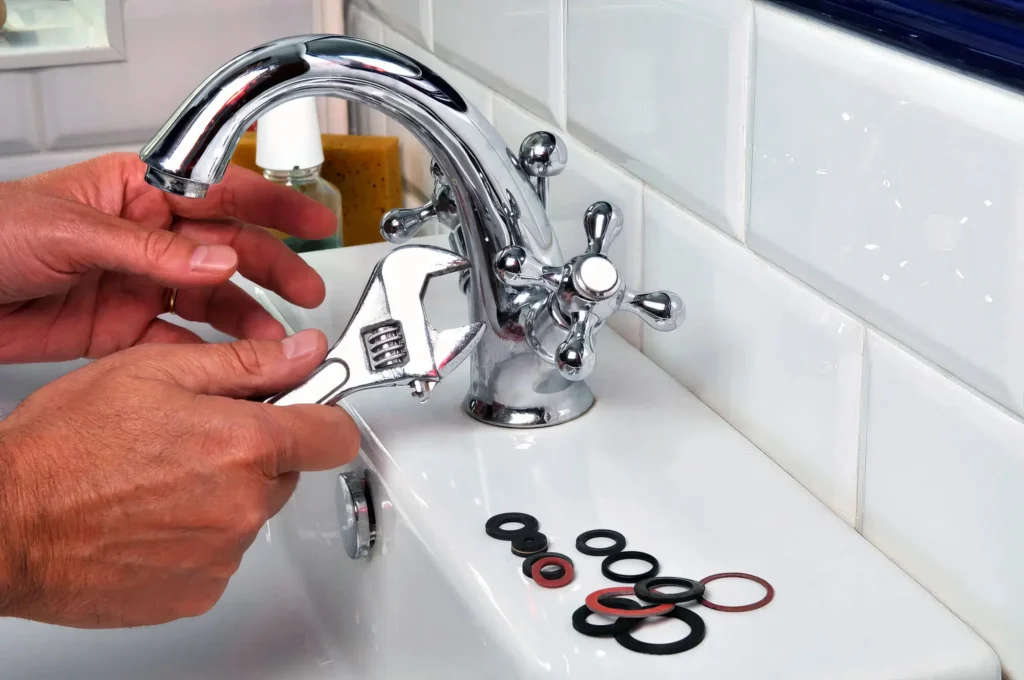 Plumber performing maintenance on a bathroom faucet in Westminster