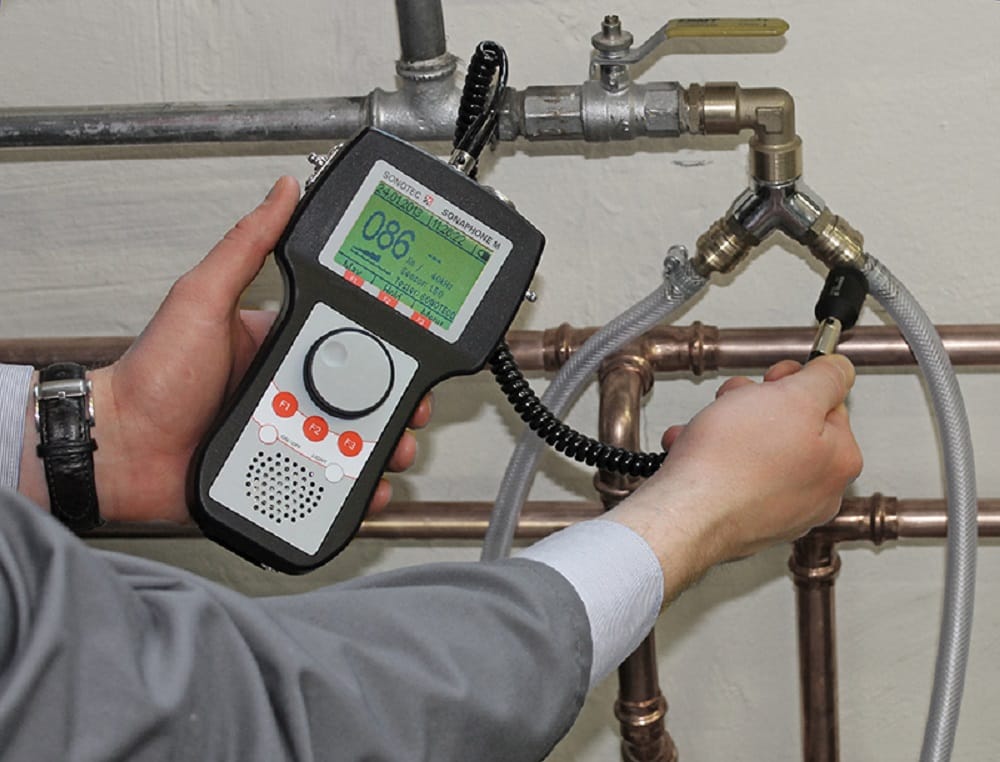 Plumber testing pipes with electronic leak detection equipment in Westminster