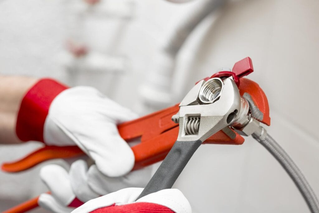 Plumber holding pipe wrenches for an emergency repair in Westminster