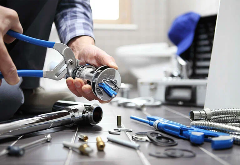 Technician repairing a plumbing fixture with professional tools in Westminster