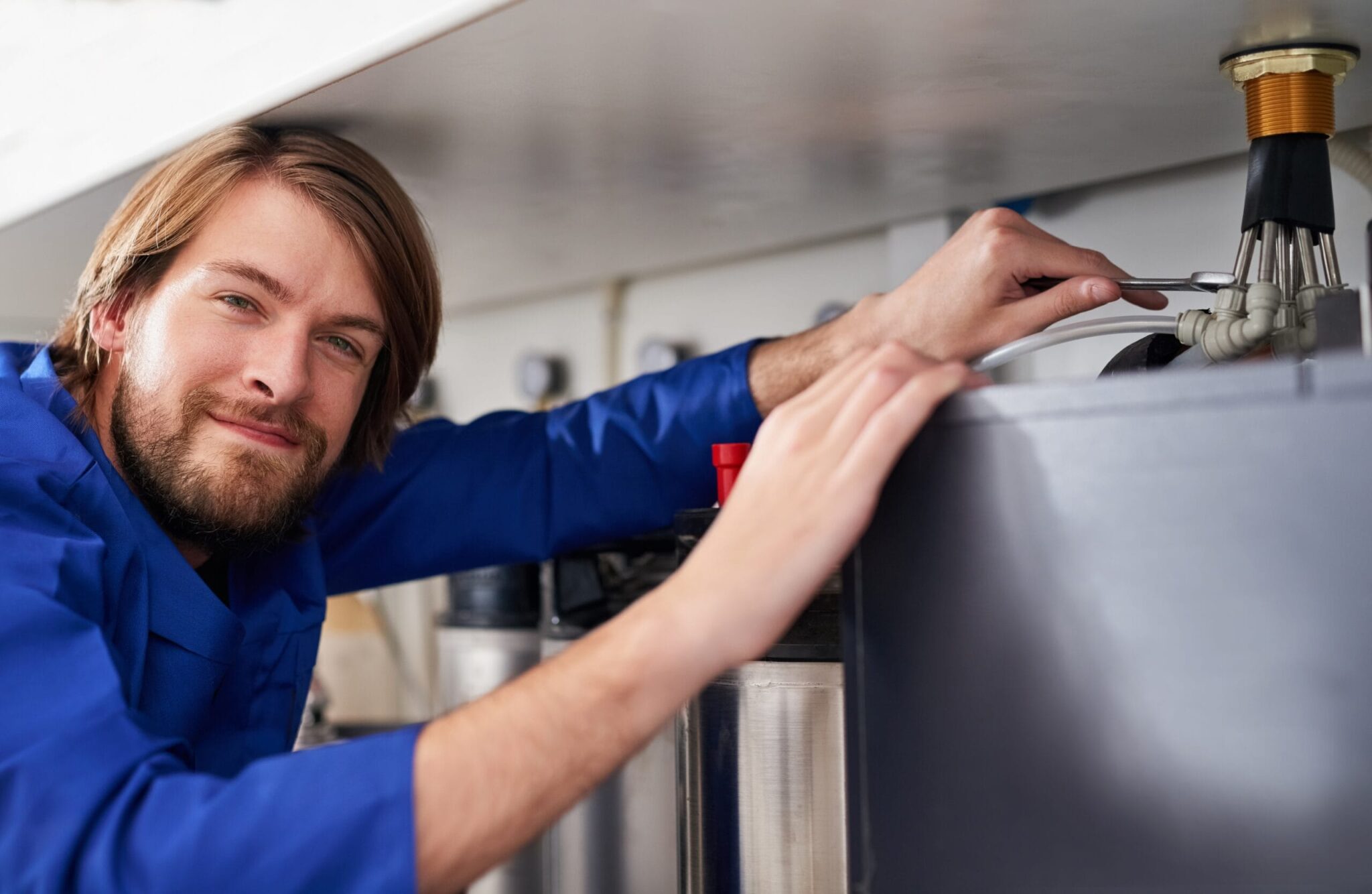 Technician servicing a residential water heater tank in Westminster