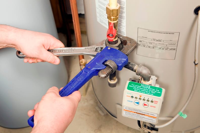 Plumber repairing a water heater valve in Westminster